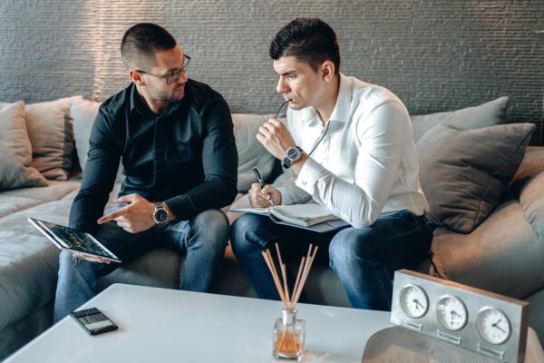 Two Businessmen Sitting on the Gray Sofa