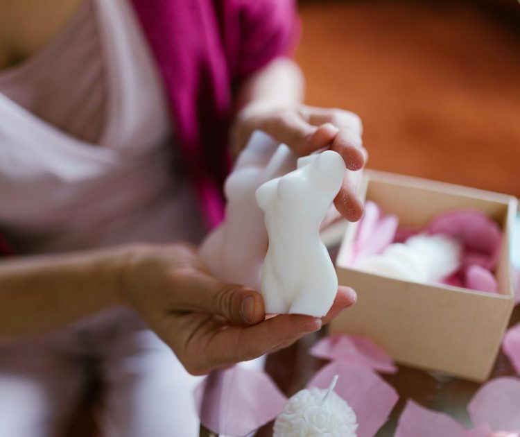 A Close-Up Shot of a Woman Holding a Body Shaped Candle