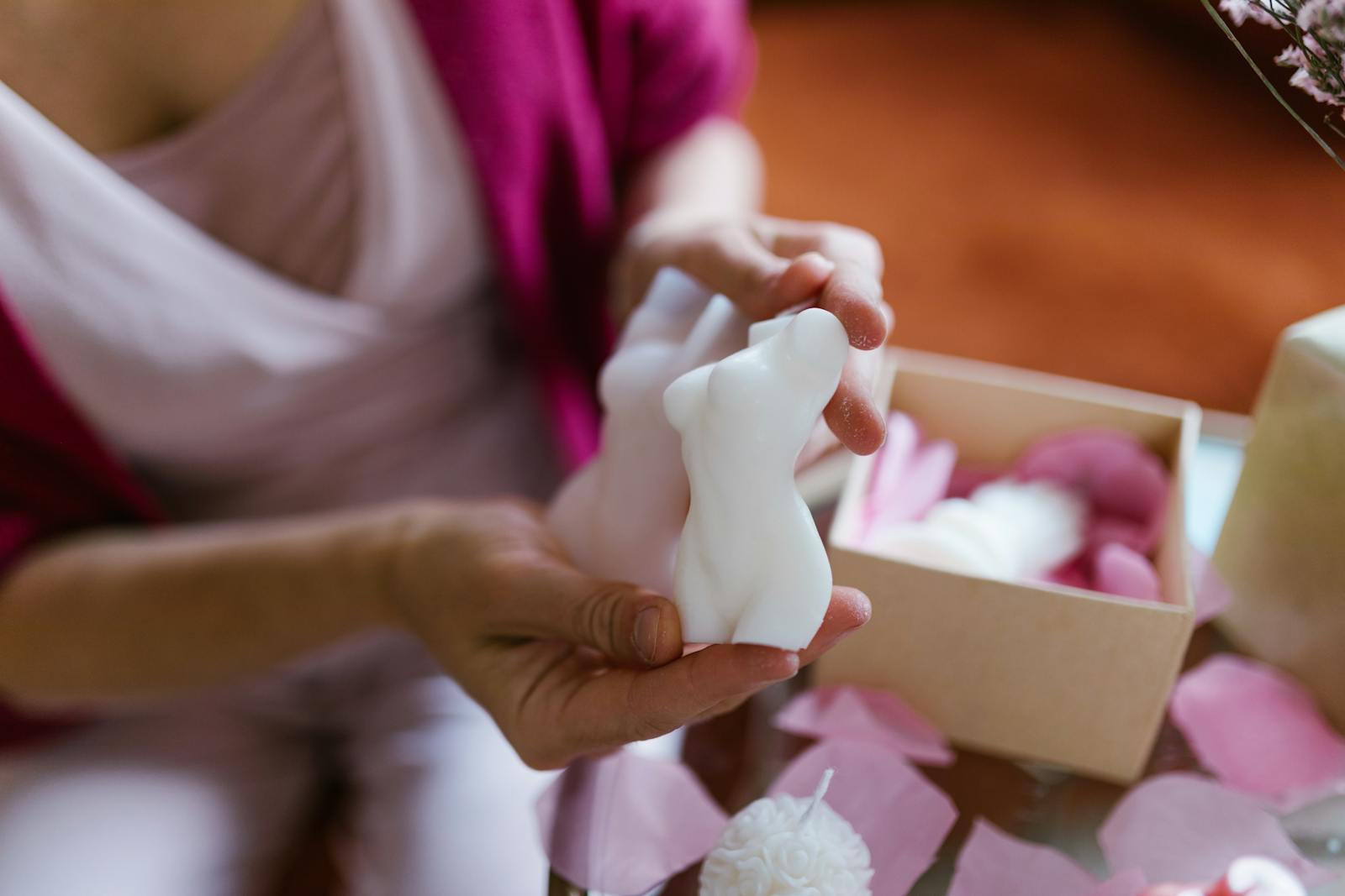 A Close-Up Shot of a Woman Holding a Body Shaped Candle